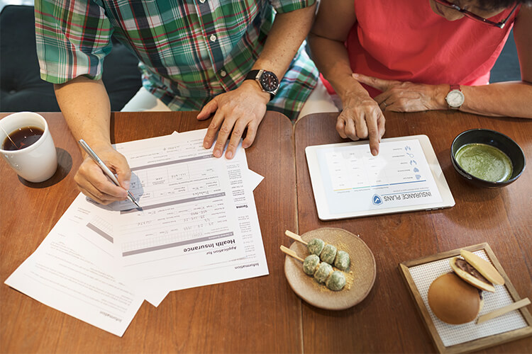 couple filling out insurance forms at a table