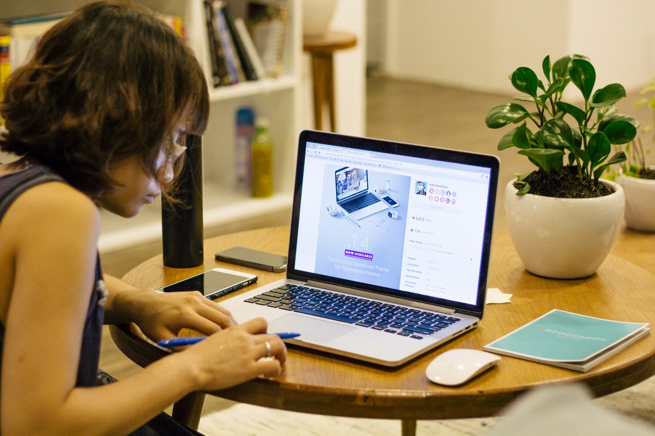 A woman sits at a table and studies on her computer