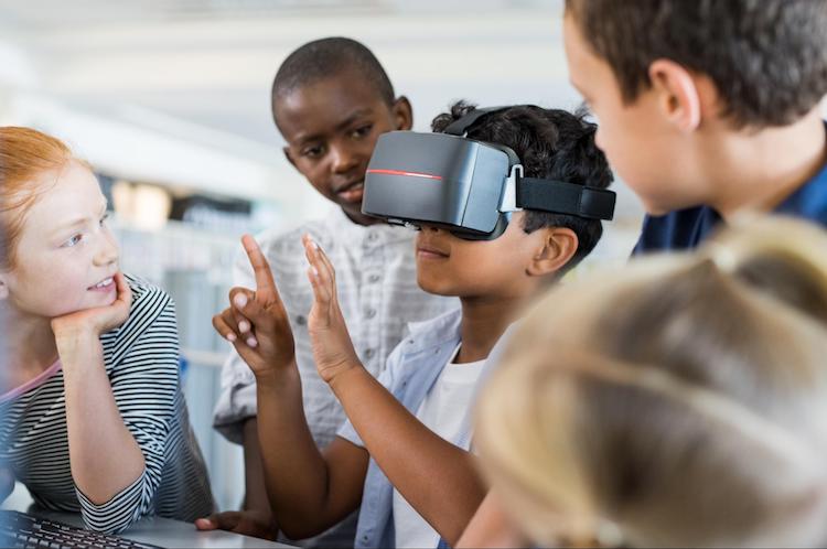  A student wears a virtual reality headset and counts while his classmates watch