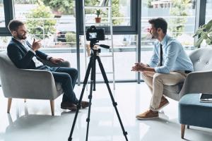 A journalist conducts a video interview for his podcast.