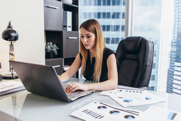 Accountant working on tax software in office space with downtown view