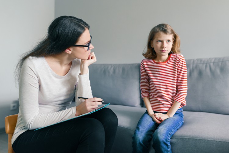 A child psychologist talks with a young girl