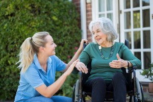 A nursing home caregiver assists a resident
