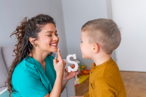 A speech therapist works with a child.