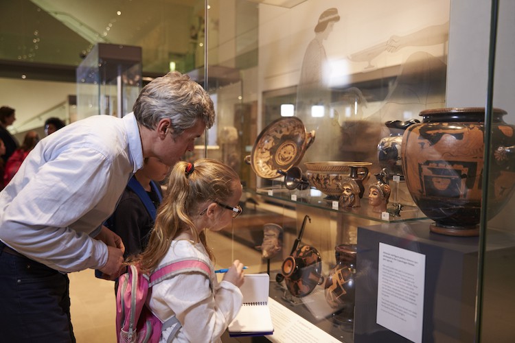Docent educates child about artifacts.
