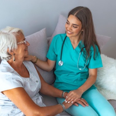 A hospice care worker talks with a patient.
