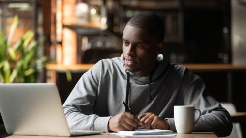 A focused student studying online using a laptop.