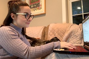 Stephanie Marchetti works on her laptop in a livingroom
