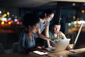 a group of people standing in front of a computer and reading