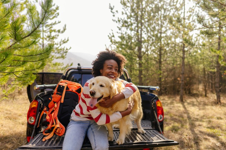 A dog and owner sit on a pickup liftgate for doggy date night.