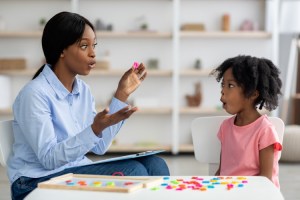 A speech-language pathologist works with a young disfluency client.