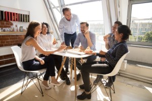 Motivated employees eat pizza in an office.