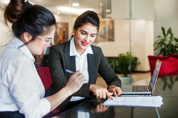 client of a loan officer signs paperwork in formal office space setting