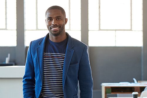 Smiling man standing in front of window