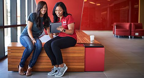 Two female students looking at a tablet