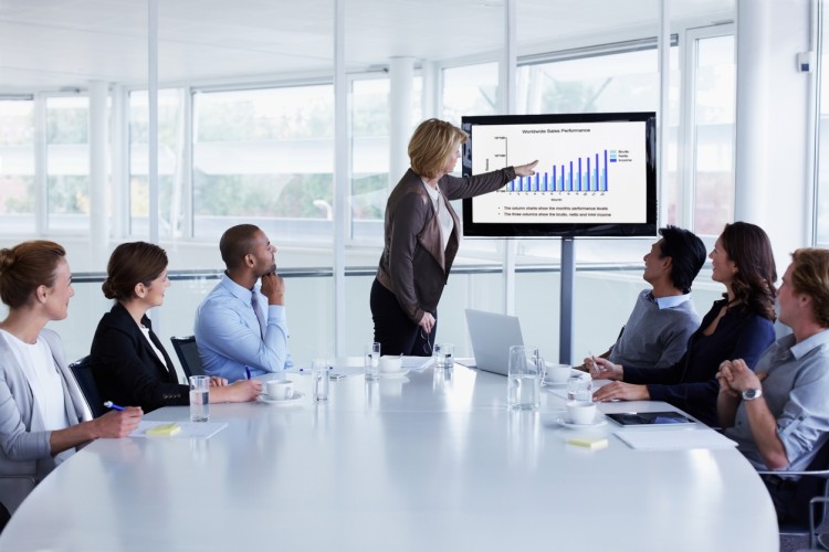 A chief marketing officer leads a meeting in a conference room.