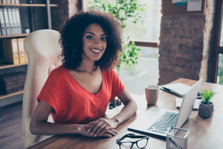 Compensation manager smiling and working with a desktop.