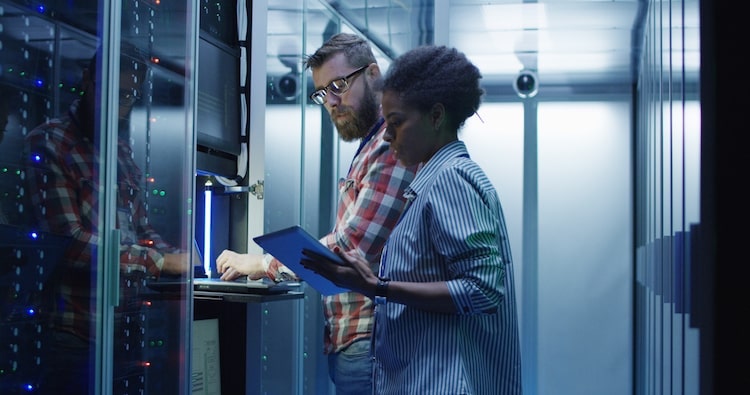 Two computer systems analysts configure server hardware.