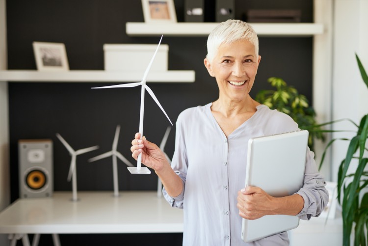 A businessperson displays a model of a windmill used to reduce a company’s carbon footprint.