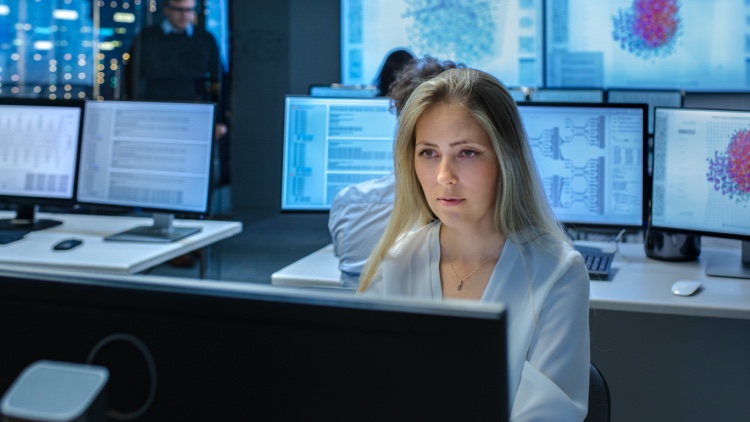 A female cybersecurity specialist works in a data center