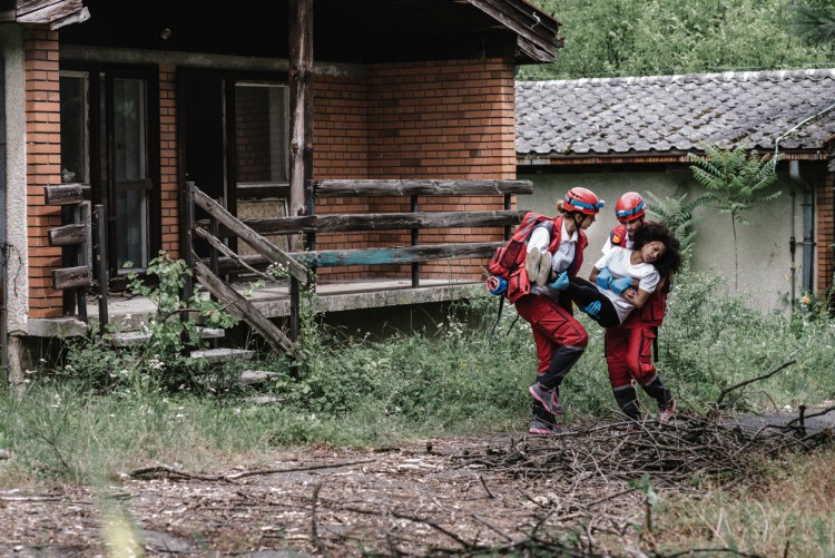 Disaster relief workers aiding a survivor.