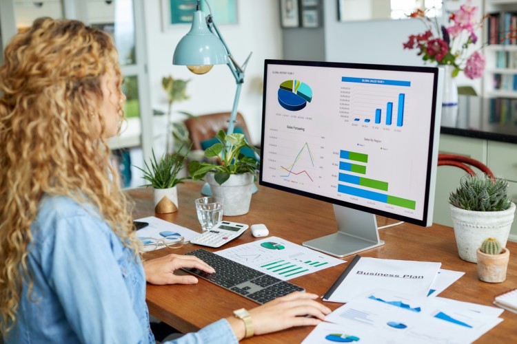 A person reviews financial data on a monitor.