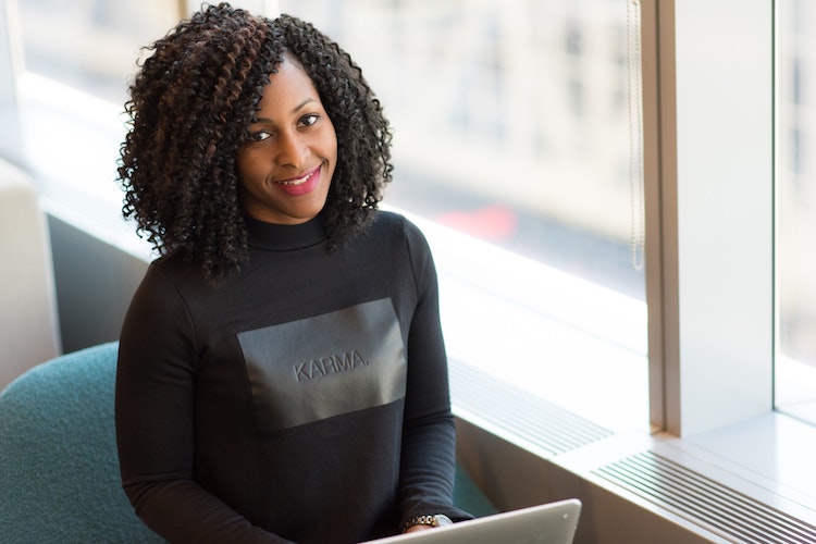 a smiling accountant sitting at a desk in front of a laptop