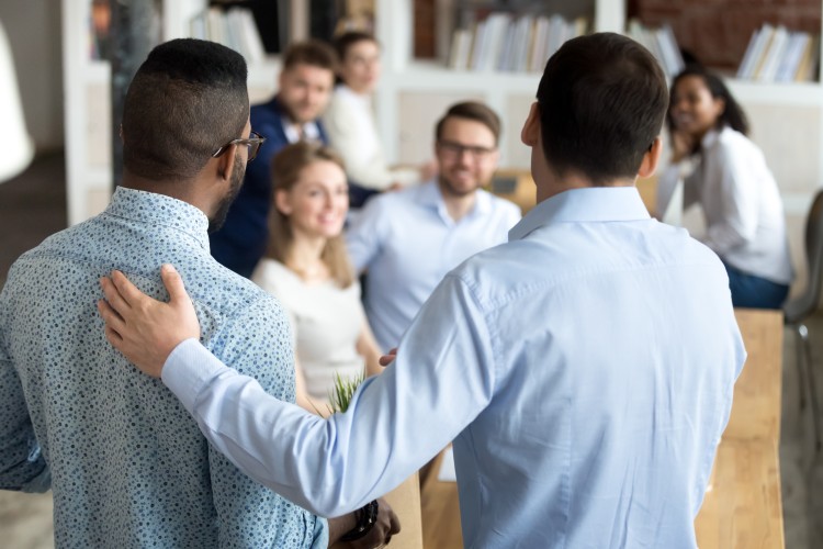 Office managers speaking in front of a group of people.