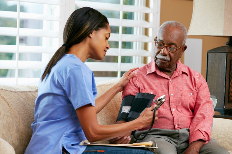 A patient care assistant measures a patient’s blood pressure
