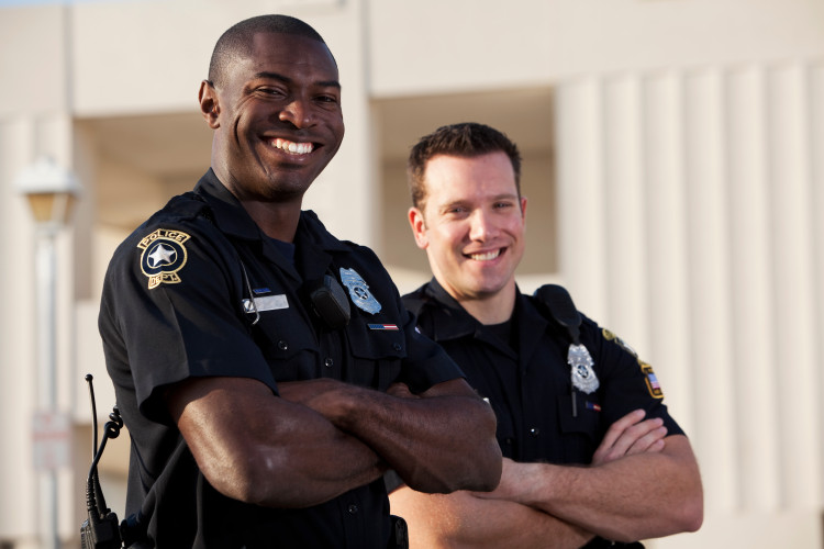 Two police officers smiling with arms crossed