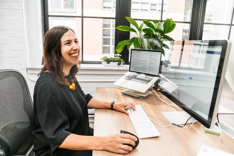 System analyst smiling and working in her desktop.