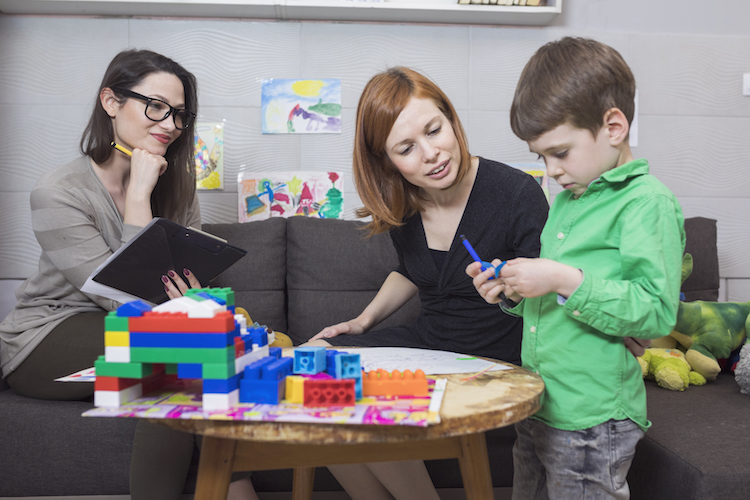 A social service specialist conducts an observation for a child