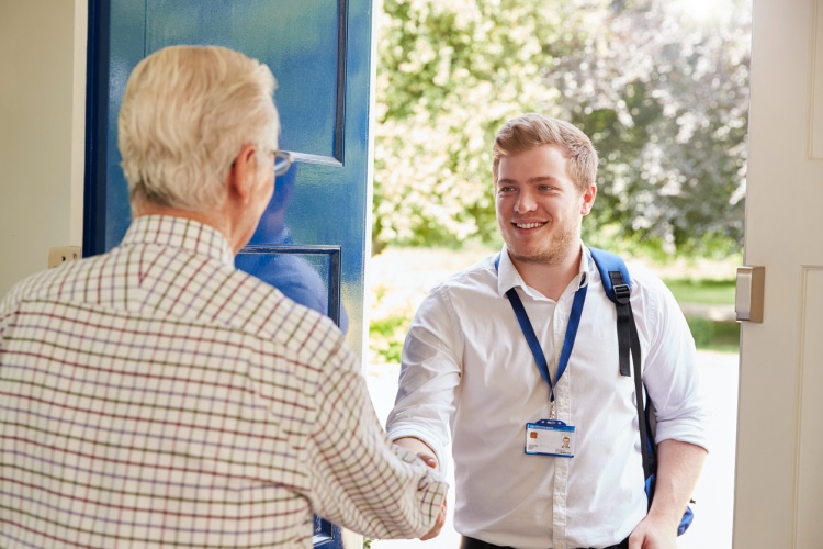 A social worker visits an elderly man at home