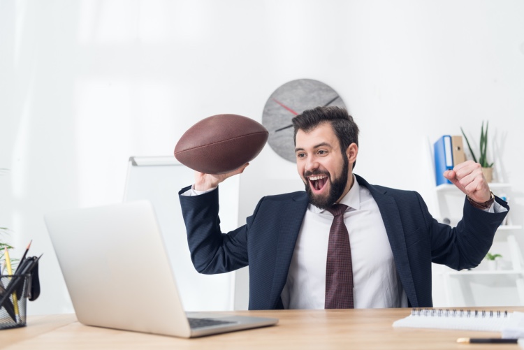 A sports agent watches a football game.