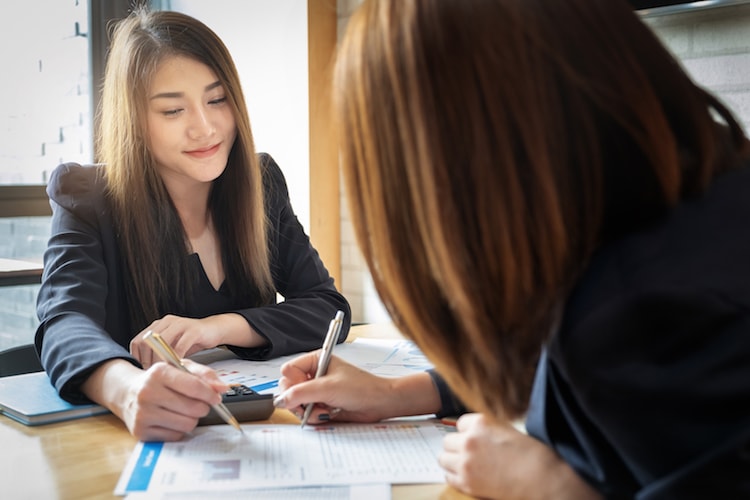 Female statistical consultant reviewing data with a client. 