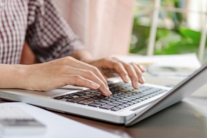 hands typing on a laptop keyboard