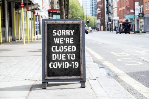 A sign outside a business announces it is closed because of COVID-19.