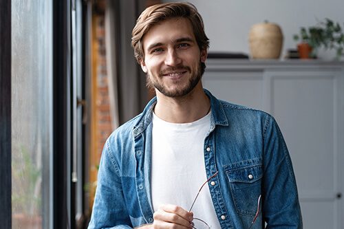 Man standing in home office smiling