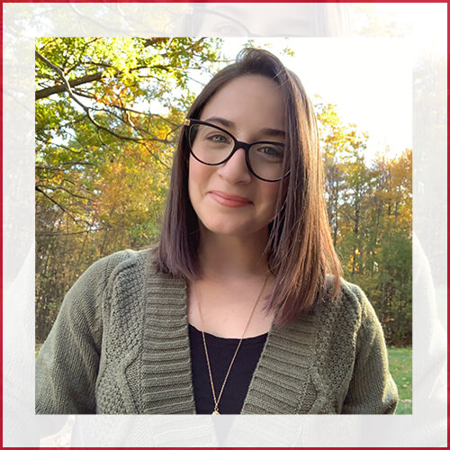 Stephanie Marchetti headshot in green sweater in front of trees