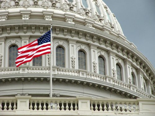 The American flag waving in front of the U.S. Capitol.
