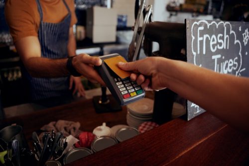 A shopper buys coffee using contactless payment.