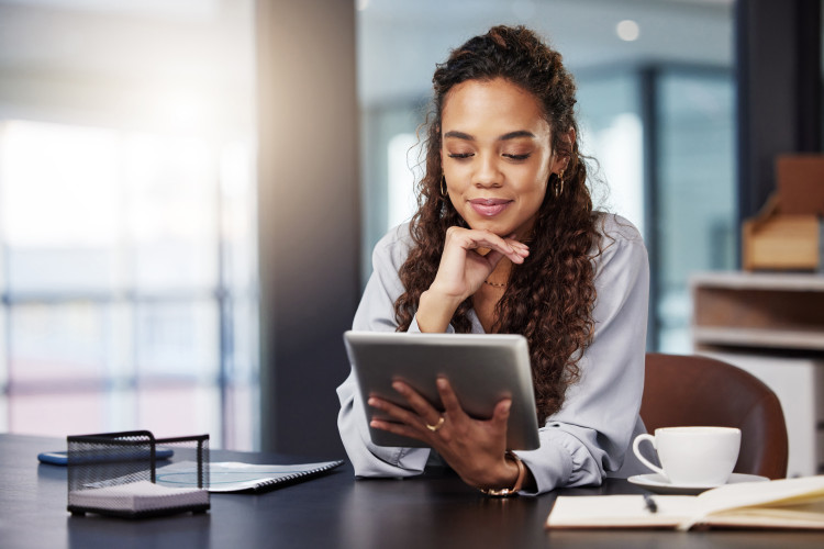 A smiling person looking at a tablet while taking a break.