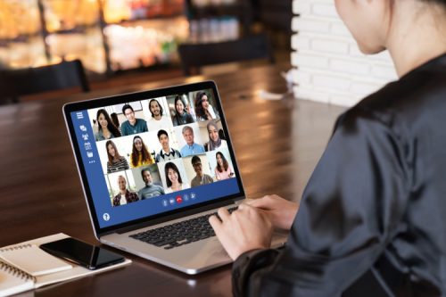 A change manager works with a remote team on a laptop.